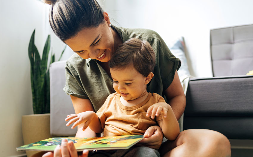 This is an image of a woman reading a book to her small child.